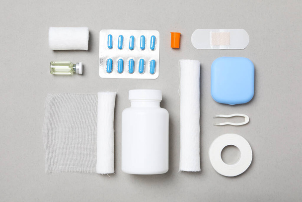 First aid kit supplies on gray background - Foto, afbeelding