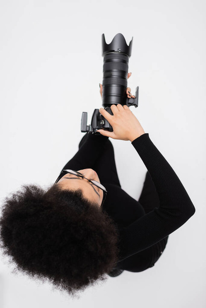 top view of african american photographer in black clothes taking photo on digital camera isolated on grey - Φωτογραφία, εικόνα
