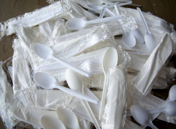 A pile of unopened wrapped plastic cutlery - Photo, Image