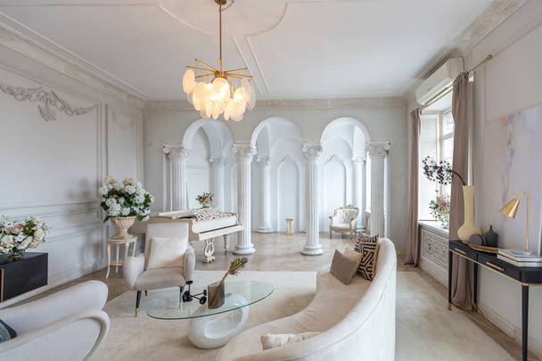 rich luxurious interior of a cozy room with modern stylish furniture nd grand piano, decorated with baroque columns and stucco on the walls - Foto, immagini
