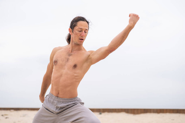 Caucasian man practices martial arts outdoors. balance and meditation - Fotó, kép