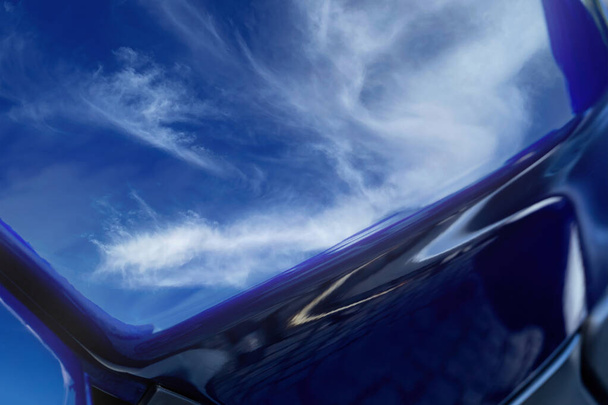 Blue tank of a motorcycle with the sky reflected in it with clouds. Background close up - Photo, Image
