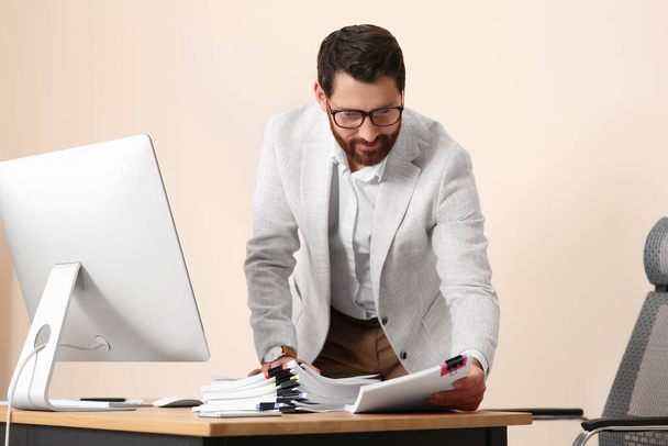Happy businessman working with documents in modern office - Foto, afbeelding