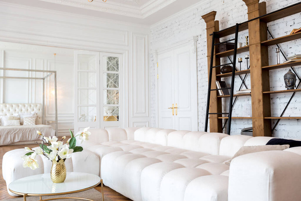 modern interior of a luxurious large bright two-room apartment. white walls, luxurious expensive furniture, parquet flooring and white interior doors - Fotó, kép
