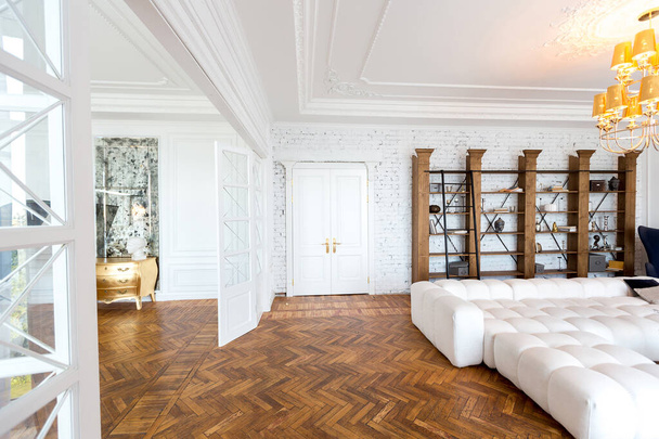 modern interior of a luxurious large bright two-room apartment. white walls, luxurious expensive furniture, parquet flooring and white interior doors - Foto, immagini