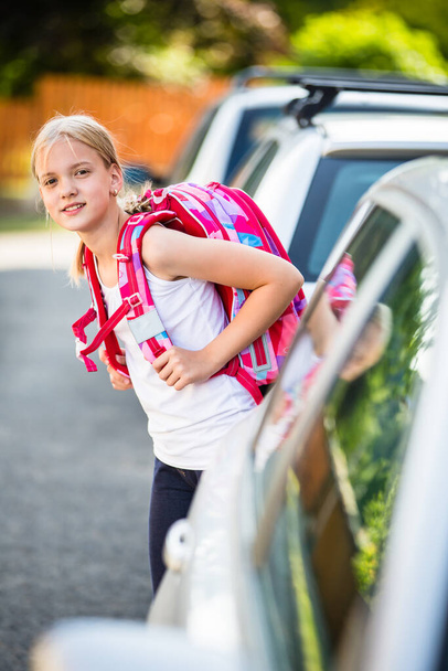 Cute little girl going home from school, looking well before crossing the street - Foto, Imagen