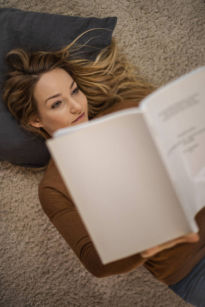 Pretty, young woman reading at home, studing for class - Foto, imagen