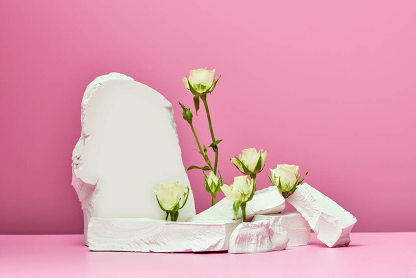 White stones and white roses isolated on pink background. podium for presentation products and cosmetics - Photo, Image