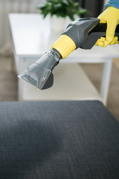 清掃サービス会社の従業員は、プロの機器とフラット家具から汚れを除去します。掃除機を洗うと男の腕のクリーニングソファ - 写真・画像