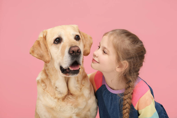 Young girl with her adorable dog on pink background - Foto, Bild