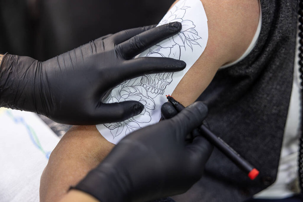 Tatuointisalongissa. Pitkätukkainen nainen kokeilee skretchiä tatuointiin - Valokuva, kuva