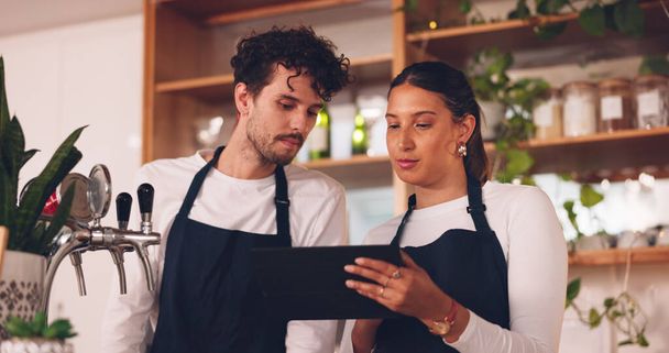 Barista team, talking with tablet in coffee shop, man and woman, discussion about work schedule or inventory check. Communication, technology with online system in cafe, working and manage sales. - Foto, Imagen