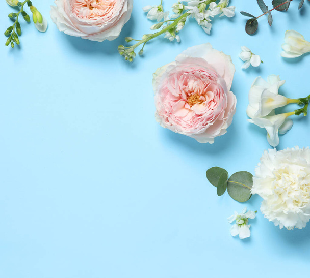 Flat lay composition with different beautiful flowers on light blue background. Space for text - Photo, Image
