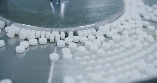 白い錠剤は、医薬品工場のワークショップで金属自動ライン上に移動します。薬の生産プロセス,薬.工場設備や機械コンベア。薬のビューはコンベアベルトに沿って動きます. - 映像、動画
