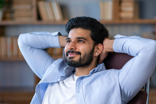 Cheerful Arab Freelancer Guy Leaning Back In Chair, Relaxing After Successful Work, Sitting At Table With Laptop Computer In Home Office, Millennial Man Resting At Workplace With Hands Behind Head - Foto, imagen