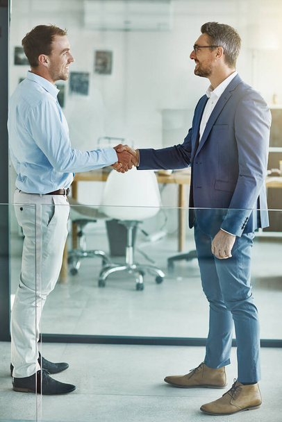 Theyre set to succeed together. two businessmen shaking hands in an office - 写真・画像