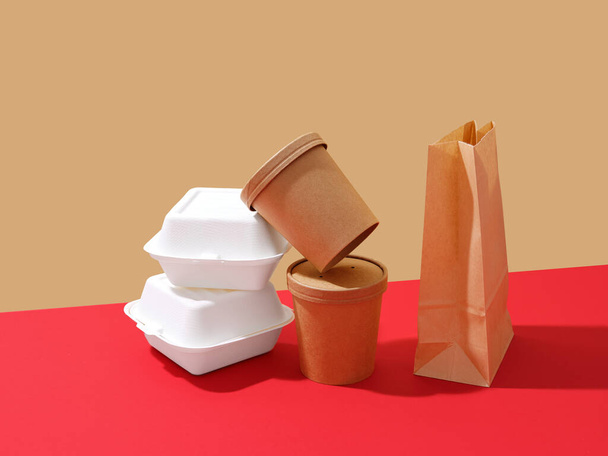 Embalaje de comida para llevar: cajas y contenedores sobre un fondo colorido con espacio de texto. Concepto minimalista - Foto, imagen