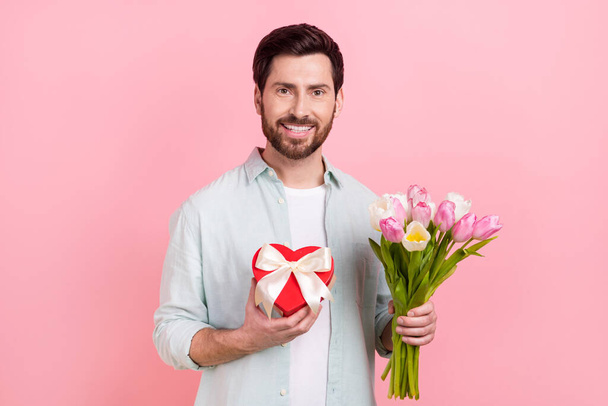 Photo portrait of nice young male bouquet boyfriend tulips 8 march candy box wear trendy blue garment isolated on pink color background. - Фото, изображение
