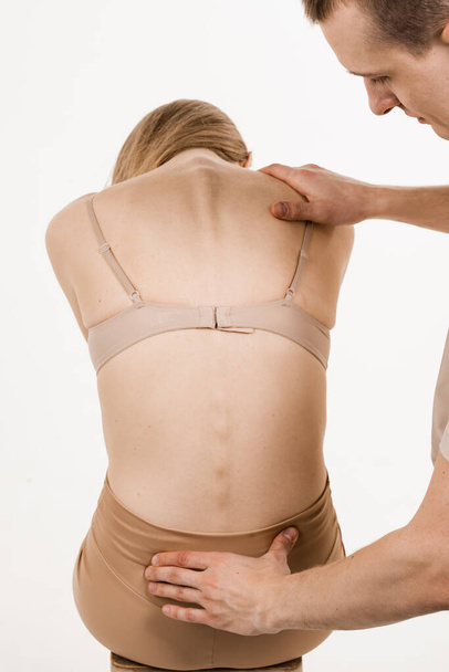 Examination of scaleosis and hernia of girl on white background. Orthopedist traumatologist examines back, lumbar discs for diagnosis of spondylosis - Zdjęcie, obraz
