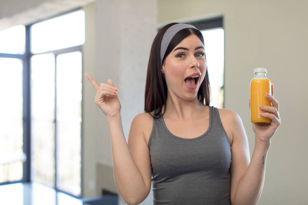 pretty young woman feeling like a happy and excited genius after realizing an idea. orange juice concept - 写真・画像