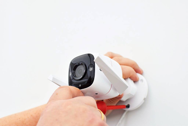 Installing a home security camera. - 写真・画像