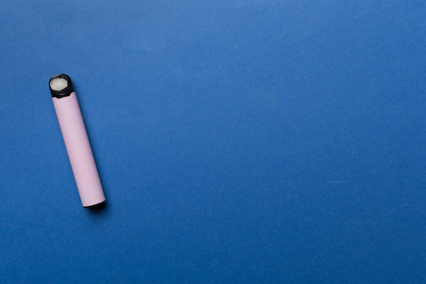 Disposable electronic cigarette on color background, top view - Fotó, kép