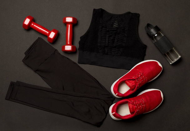 Schwarzes Fitnessstudio-Outfit auf farbigem Hintergrund, Draufsicht - Foto, Bild