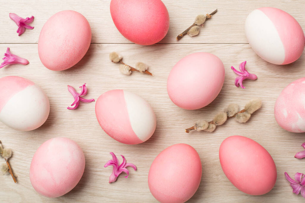 Pink Easter eggs with decor on wooden background, top view - Foto, imagen