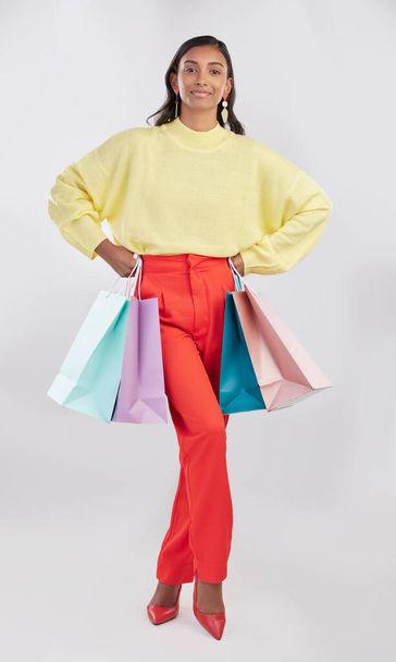 Portrait, fashion and woman with bags, shopping and glamour against a white studio background. Face, female shopper or model with products, elegant person and holding gifts with smile, brand and sale. - Fotó, kép