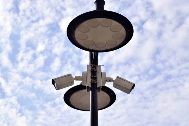 Surveillance cameras are attached to a lamppost. - 写真・画像