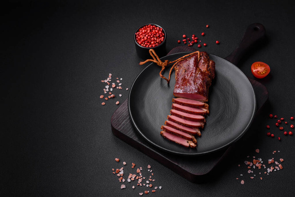 Delicious duck fillet or breast grilled or smoked with spices and salt on a dark concrete background - Photo, Image