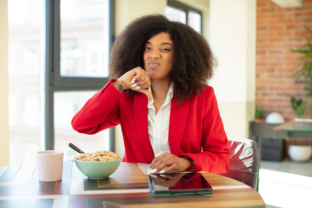 pretty afro black woman feeling cross,showing thumbs down. having breakfast concept - Foto, Bild