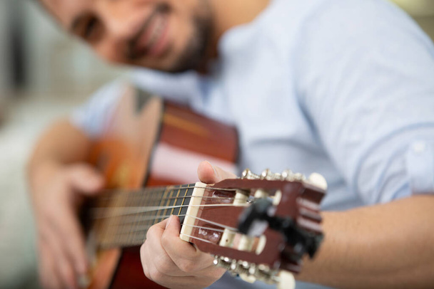guitar in the hands of a smiling male musician - Foto, Bild