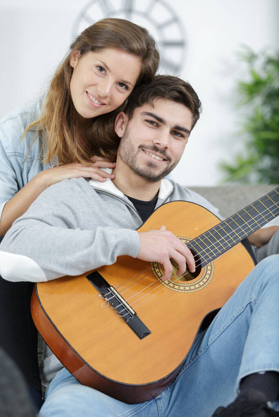 loving couple with guitar in the room at home - Fotografie, Obrázek
