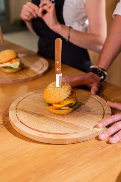 Beef burgers on wooden desk. Fat unhealthy food closeup - Foto, imagen