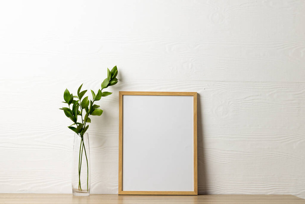 Wood empty frame with copy space and plant on table against white wall. Mock up frame template, interior design and decoration. - Fotoğraf, Görsel