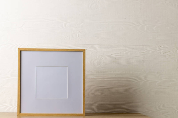 Wood empty frame with copy space on table against white wall. Mock up frame template, interior design and decoration. - Foto, imagen