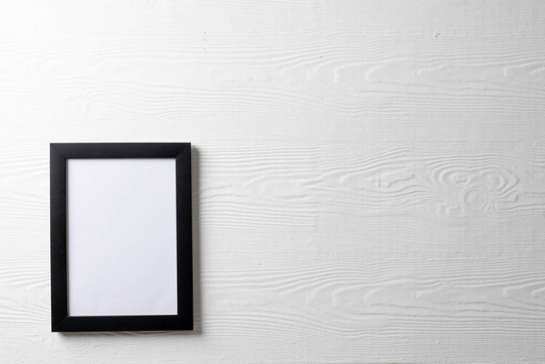 Black empty frame with copy space on white wall. Mock up frame template, interior design and decoration. - Фото, изображение