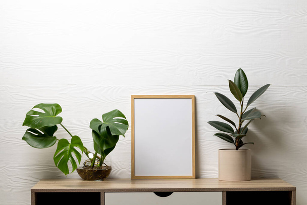 Wood empty frame with copy space and plants in pots on table against white wall. Mock up frame template, interior design and decoration. - Valokuva, kuva