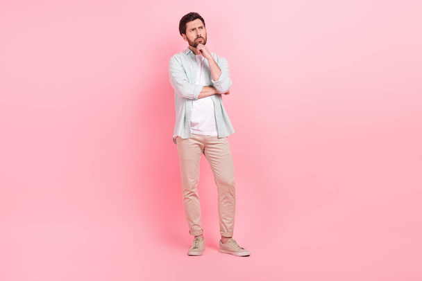 Full length photo of nice young male deep minded pensive thoughtful dressed stylish blue garment isolated on pink color background. - Foto, Imagem