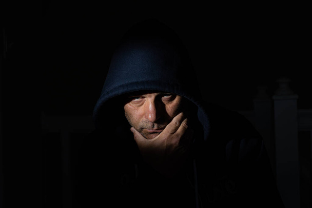 Uomo depresso con un cappuccio e un viso spaventoso - Foto, immagini