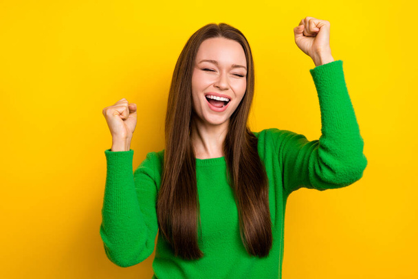 Photo of satisfied astonished girl closed eyes shout yes raise fists isolated on yellow color background. - Fotografie, Obrázek