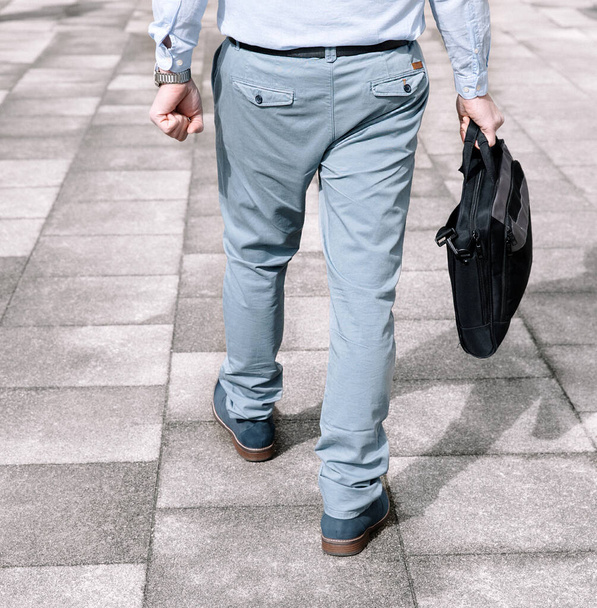 Бизнесмен в светлом костюме и темном портфеле идет на работу, вид сзади - Фото, изображение