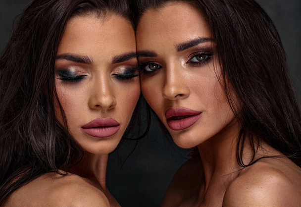 Beauty photo of two sexy women with glamour makeup. One girl is looking at the camera, second one has closed eyes.  Closeup portrait. - Fotó, kép