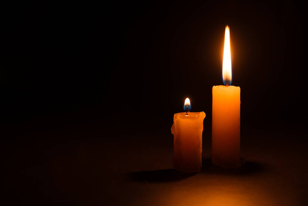 Helle brennende Kerze in der Dunkelheit. Gedenken und Symbol des Volkstrauertages. Helle Kerze in Großaufnahme - Foto, Bild