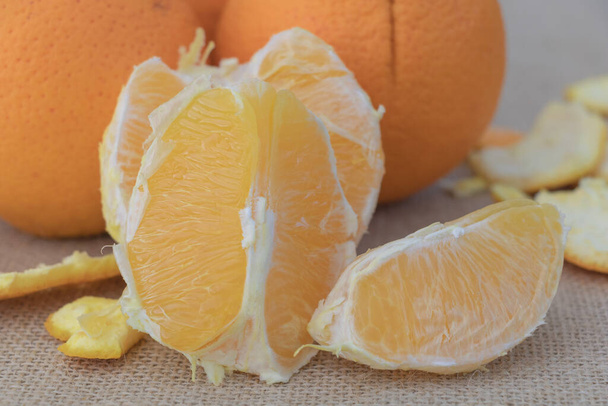 Sinaasappelfruit en sinaasappelschijfjes op zak. Selectieve focus. - Foto, afbeelding