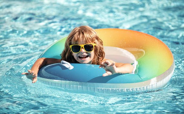 Child summer vacation. Summertime. Kid in pool. Boy swimming at aquapark. Funny boy on inflatable rubber circle - Φωτογραφία, εικόνα