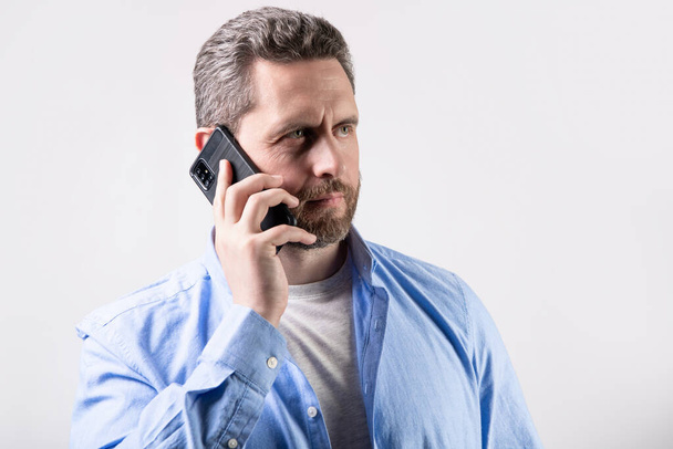 man with communication call in studio. communication call of man. photo of man having communication call. man has communication call on phone isolated on studio background. - Photo, image