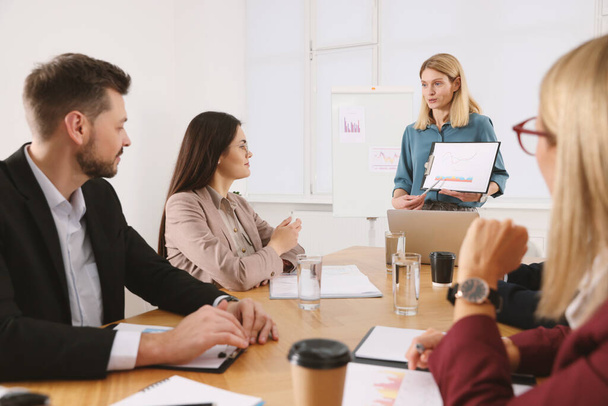 Businesswoman showing chart on meeting in office - Photo, Image