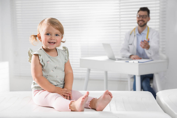 Pediatrician working at table in clinic, focus on cute little baby - Foto, Imagem